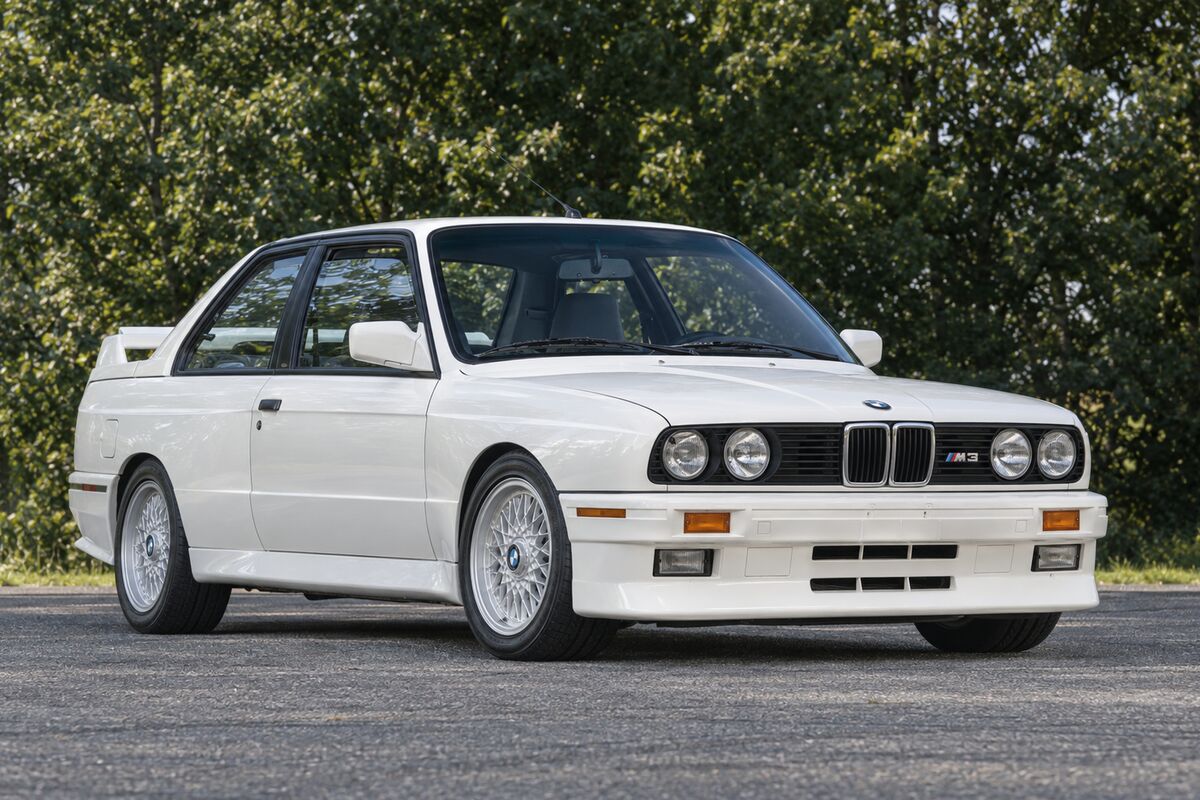 A white first-generation BMW M3 from the front right.