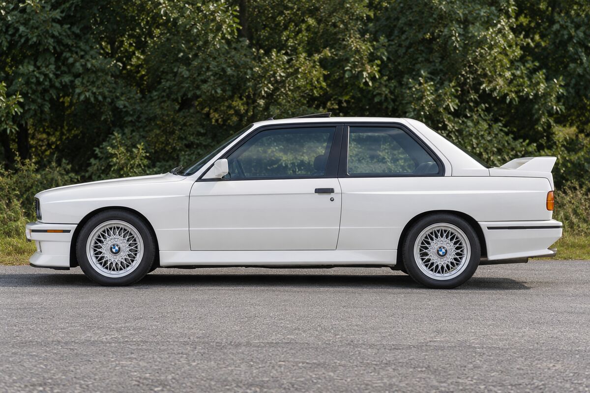 A white first-generation BMW M3 in profile.